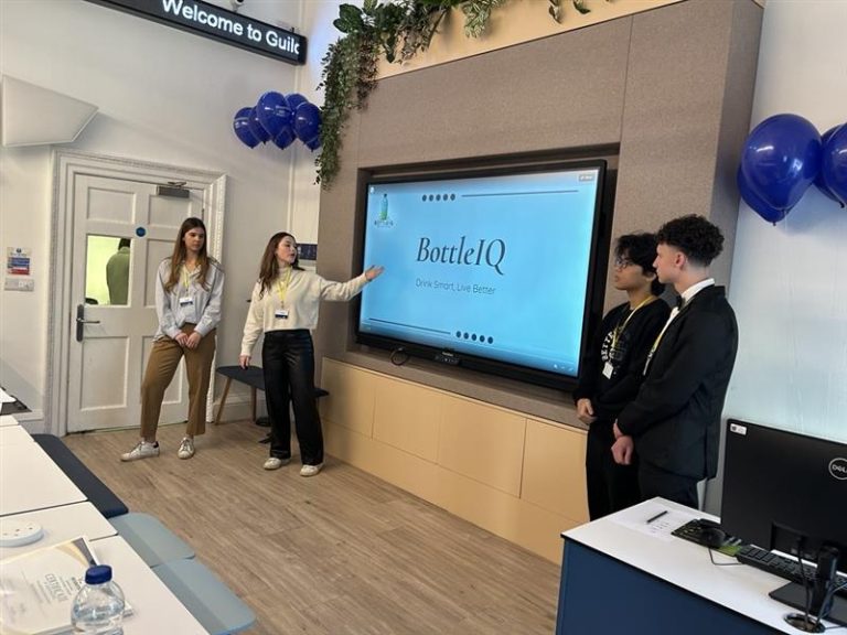 Four student presenting at a board